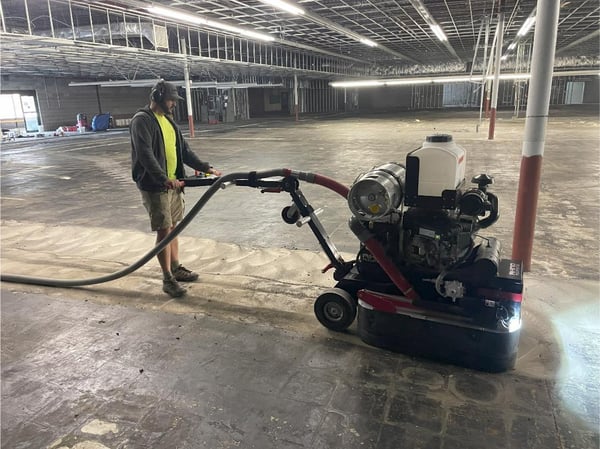 A huge commercial grinder removing the top layer of concrete.