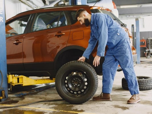 A mechanic working on a vehicle in his garage.