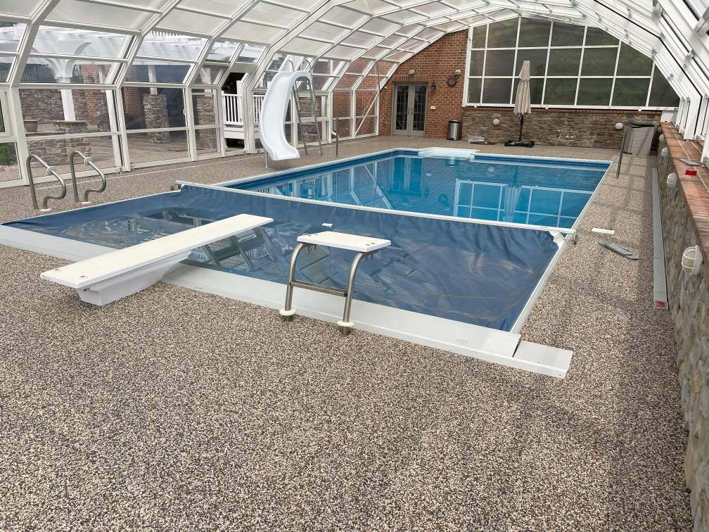 The concrete around a pool covered with river rock epoxy.